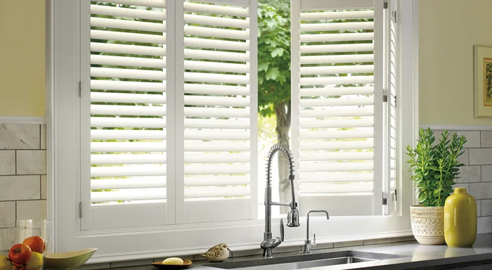 White plantation shutters above a kitchen sink