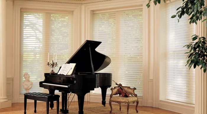 Sheer shades beside a grand piano