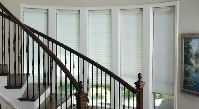 White sheer shades on windows beside a staircase