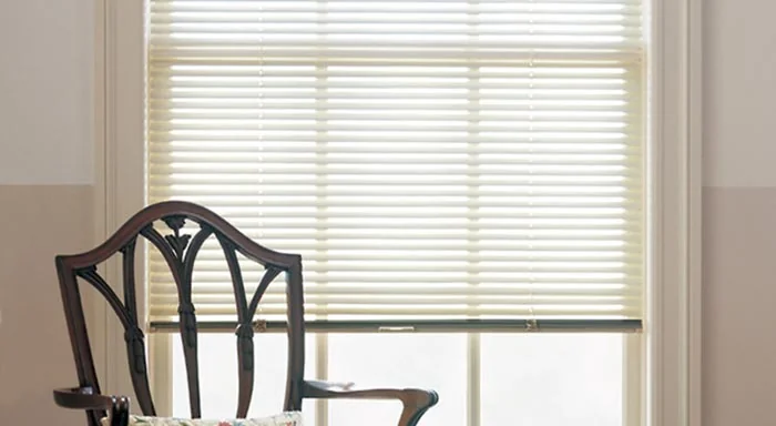 White aluminum blinds behind a dining chair