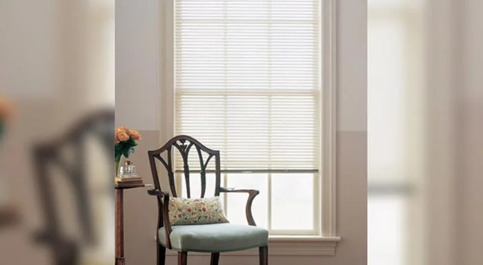 White aluminum blinds behind a dining chair