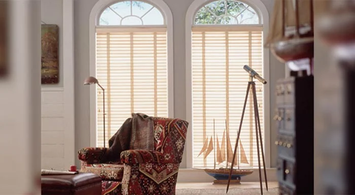 Light basswood blinds beneath arched windows