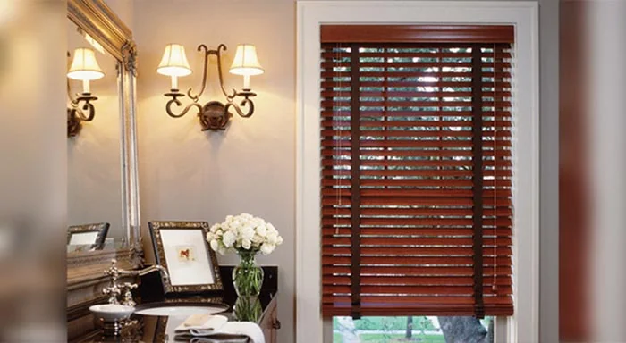 Dark basswood blinds beside a wall sconce