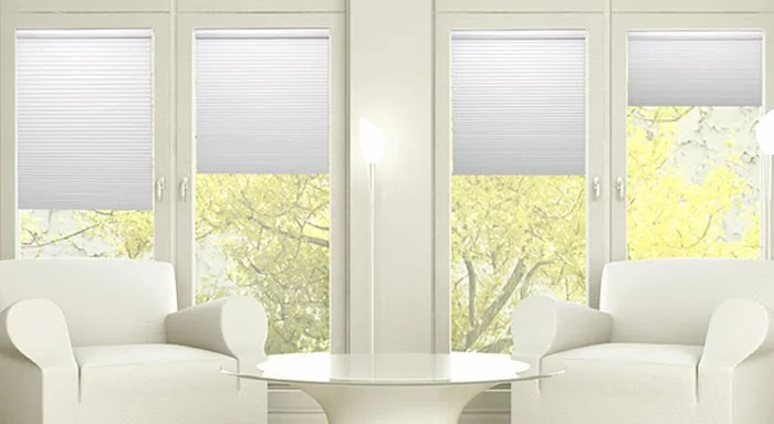 White cellular shades covering the upper portions of living room windows