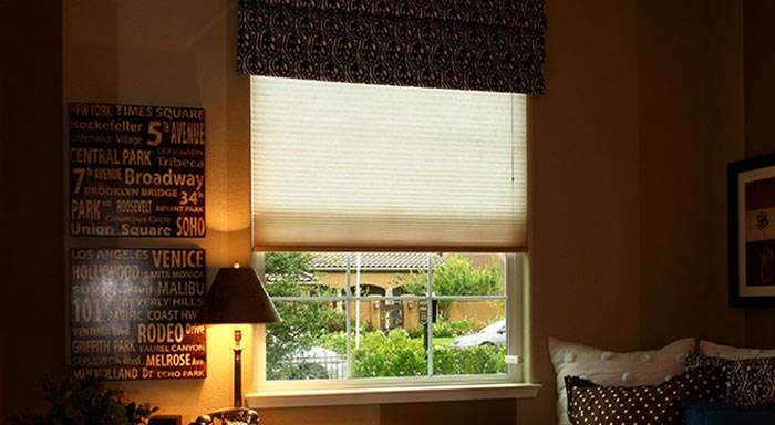 Cellular shade partially lowered over a window